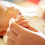 دست نوزاد در دست مادرش