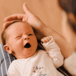 نوزادی که روی پای مادرش خوابیده