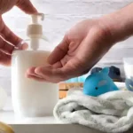 استفاده از لوسیون و نرم کنده برای پوست نوزاد خانمی که به دستش کرم می زند.