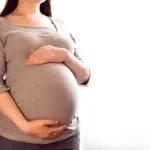 خانم بارداری که دستش روی شکمش است.